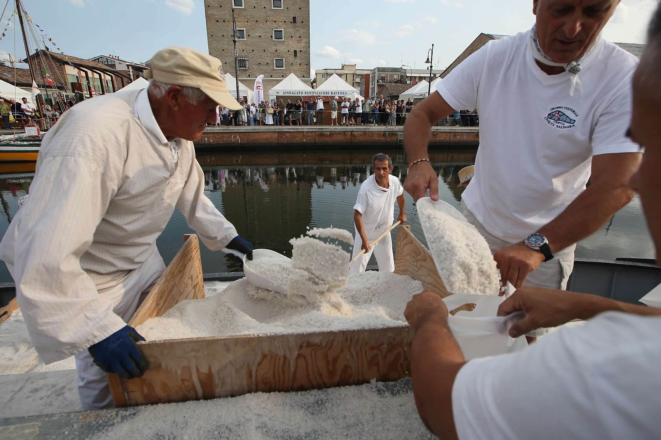 Salinari che distribuiscono il sale dolce di Cervia dalla burchiella durante la rievocazione